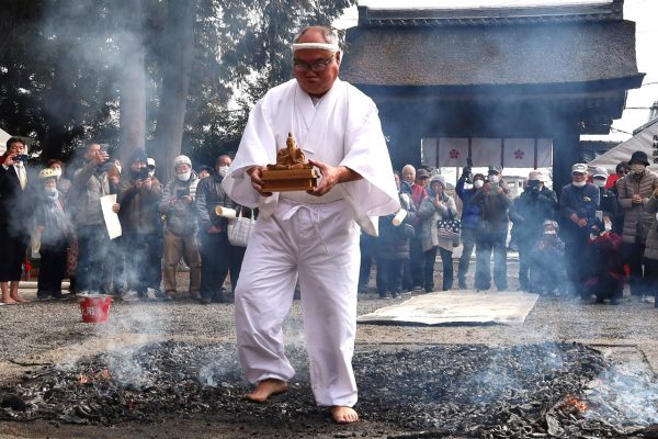 菅原道真像を抱え、はだしで渡る村田宮司